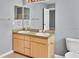 Bathroom features a double sink vanity, framed mirrors, light colored walls, and tile flooring at 685 Reindeer Dr, Kissimmee, FL 34759
