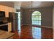 Bright dining area with stainless steel appliances, an arched window, and terra cotta tile flooring at 685 Reindeer Dr, Kissimmee, FL 34759