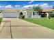 Home exterior shows a well-manicured lawn, two-car garage, driveway and white picket fence at 685 Reindeer Dr, Kissimmee, FL 34759