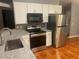 Updated kitchen features stainless steel appliances, granite counters, and white cabinets at 685 Reindeer Dr, Kissimmee, FL 34759