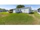 Well-maintained home featuring a spacious lawn and white exterior with a screened-in porch at 705 Prado Dr, The Villages, FL 32159