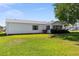 Well-kept backyard and exterior of the home, with a lush lawn and side sunroom at 705 Prado Dr, The Villages, FL 32159