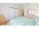 Bright bedroom with a floral comforter, closet, and door to another room at 705 Prado Dr, The Villages, FL 32159