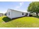 Exterior side view with lush green yard at 705 Prado Dr, The Villages, FL 32159