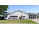 Charming single-story home with a well-maintained lawn, awnings, and enclosed patio at 705 Prado Dr, The Villages, FL 32159