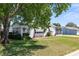 Charming single-story home with mature trees and manicured landscaping at 705 Prado Dr, The Villages, FL 32159