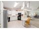 Bright kitchen with black appliances, white cabinetry, and a cozy breakfast bar at 705 Prado Dr, The Villages, FL 32159