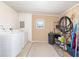 Functional laundry room with washer, dryer, storage shelves, and a practical design for efficient chores at 705 Prado Dr, The Villages, FL 32159