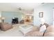 Open-concept living room with neutral colors, and seamless flow to dining area and kitchen at 705 Prado Dr, The Villages, FL 32159