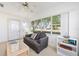 Bright living room featuring a comfortable couch, large windows and decorative ceiling fan at 705 Prado Dr, The Villages, FL 32159