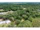 Aerial shot highlighting the home's placement within a densely wooded and private setting at 7938 Jacksons River Rd, Leesburg, FL 34788