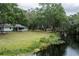 Expansive backyard featuring lush greenery extending to the waterway, perfect for outdoor activities and relaxation at 7938 Jacksons River Rd, Leesburg, FL 34788