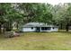 Spacious backyard bordered by mature trees, with an inviting screened-in porch and ample room for recreation and outdoor entertaining at 7938 Jacksons River Rd, Leesburg, FL 34788