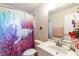 Bathroom with white cabinet and sink, tile floors and colorful shower curtain at 7938 Jacksons River Rd, Leesburg, FL 34788