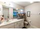 Bathroom with white vanity, a large mirror, and tile flooring throughout at 7938 Jacksons River Rd, Leesburg, FL 34788