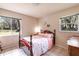 Light-filled bedroom featuring a floral-patterned bedspread and tile flooring at 7938 Jacksons River Rd, Leesburg, FL 34788