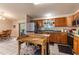 Well-lit kitchen featuring wood cabinets and an island with space for storage at 7938 Jacksons River Rd, Leesburg, FL 34788