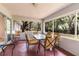 Enclosed patio features a dining table with comfortable seating and views of the surrounding landscape at 7938 Jacksons River Rd, Leesburg, FL 34788
