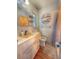 Well-lit bathroom with a single sink vanity, decorative mirror, and wood-look flooring, exudes a neat and tidy ambiance at 802 Haselton St, Eustis, FL 32726