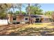 Charming single-story home featuring mature trees, a well-manicured lawn, and a cozy front porch area at 802 Haselton St, Eustis, FL 32726