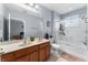 Bright bathroom with double vanity sinks, a glass-enclosed shower, and neutral tile flooring at 8256 Maritime Flag St # 103, Windermere, FL 34786