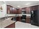 Modern kitchen featuring granite countertops, stainless steel appliances, and dark wood cabinetry at 8256 Maritime Flag St # 103, Windermere, FL 34786