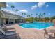 Resort-style pool area with lounge chairs, palm trees, and a covered seating area for ultimate relaxation at 8256 Maritime Flag St # 103, Windermere, FL 34786