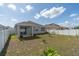 Expansive backyard featuring a covered patio, landscaping, and privacy fence at 853 Laurel View Way, Groveland, FL 34736