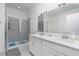 Bright bathroom featuring a sleek glass-enclosed shower and double sink vanity for convenience at 853 Laurel View Way, Groveland, FL 34736