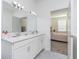 Bathroom with a double sink vanity, modern lighting, and convenient access to the bedroom at 853 Laurel View Way, Groveland, FL 34736