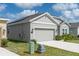 Side view of a well-maintained house showcasing an attached garage and lush green lawn at 853 Laurel View Way, Groveland, FL 34736