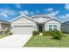 Charming single-story home with a well-manicured lawn and attached two-car garage at 853 Laurel View Way, Groveland, FL 34736