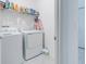 Bright laundry room with white washer and dryer, plus storage shelves for supplies at 853 Laurel View Way, Groveland, FL 34736