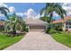 Charming single-story home featuring a paved driveway, lush landscaping and a two-car garage at 9019 Se 177Th Grassmere St, The Villages, FL 32162