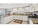 Bright kitchen features white cabinets, tile floors, granite countertops and stainless appliances at 9019 Se 177Th Grassmere St, The Villages, FL 32162