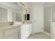 Bathroom with dual sinks, white cabinets, and a glass-enclosed shower at 9081 Saint Andrews Way, Mount Dora, FL 32757