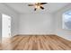Spacious bedroom featuring wood floors, ceiling fan, and a large window at 9081 Saint Andrews Way, Mount Dora, FL 32757
