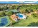 Aerial view of community featuring tennis courts, pool, clubhouse, and green spaces at 9081 Saint Andrews Way, Mount Dora, FL 32757