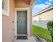 Inviting front door with a neutral color, trimmed in white, and framed by the home's siding at 9081 Saint Andrews Way, Mount Dora, FL 32757