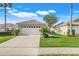 Charming single-story home featuring a well-manicured lawn, stone accents, and a two-car garage at 9081 Saint Andrews Way, Mount Dora, FL 32757