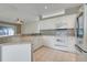 Bright kitchen features white cabinets, modern appliances, and a convenient breakfast bar area at 9081 Saint Andrews Way, Mount Dora, FL 32757