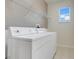 Convenient laundry room features a washer, dryer, and shelving for organized storage at 9081 Saint Andrews Way, Mount Dora, FL 32757