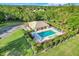 Stunning aerial view of pool with lounge chairs and manicured hedges at 9081 Saint Andrews Way, Mount Dora, FL 32757