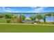 Stunning waterfront home featuring lush lawn and mature trees overlooking the serene lake at 9510 Suggs Rd, Clermont, FL 34711