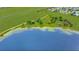 Panoramic aerial view of a serene lakefront property with ample greenery, tree coverage and an open sky at 9510 Suggs Rd, Clermont, FL 34711