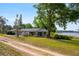 Inviting single-story home with a serene lake view, complemented by mature trees and lush greenery at 9510 Suggs Rd, Clermont, FL 34711