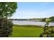 Scenic lake view featuring lush greenery and distant houses on the horizon at 9510 Suggs Rd, Clermont, FL 34711