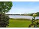 Picturesque lake view featuring calm waters and distant properties, framed by lush greenery in the foreground at 9510 Suggs Rd, Clermont, FL 34711