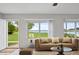 Cozy living room with neutral decor, large windows with lake views, and an open doorway at 9510 Suggs Rd, Clermont, FL 34711