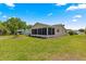 Lush backyard featuring a well-maintained lawn and screened-in porch for outdoor relaxation at 9645 Se 173Rd Pl, Summerfield, FL 34491